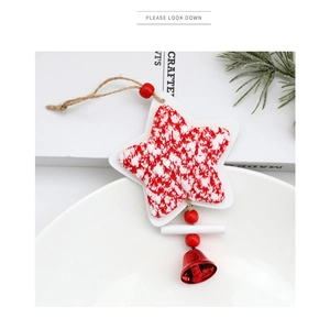 Detalle de adorno navideño de estrella tejida roja y blanca con cascabel y cuerda
