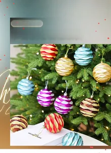 Close-up of glittered Christmas balls with wave texture hanging on a glowing tree