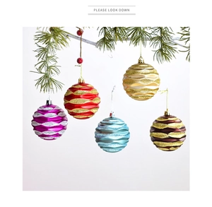 Detail of 8cm glitter wavy Christmas ball ornaments hanging on white festive branches