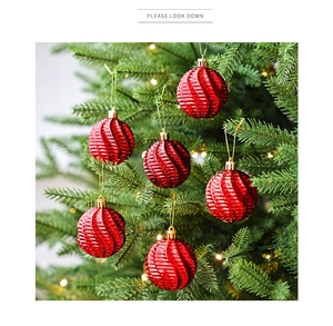 Gros plan de boules de Noël rouges de 6cm avec texture en spirale sur un sapin festif
