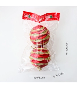 Detail of 8cm red Christmas balls with gold glitter patterns in festive packaging