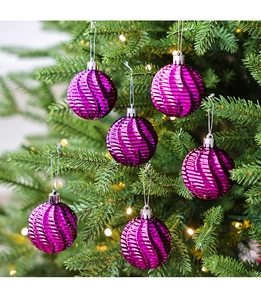 Gros plan de boules de Noël violettes de 6cm avec texture spirale sur un sapin festif