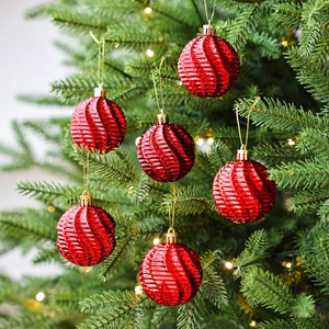 Lot de boules de Noël rouges à spirales suspendues sur un sapin avec lumières chaudes