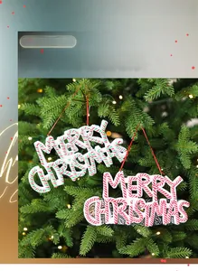 Macro shot of candy cane striped Merry Christmas hanging ornament on a lit tree