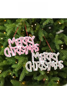 Festive Merry Christmas letter hanging ornaments on tree with warm lights and red ropes