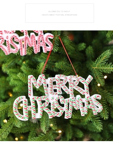 Close-up of Merry Christmas candy cane style sign hanging on a festive Christmas tree