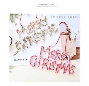 Close-up of candy cane striped Merry Christmas hanging ornaments with red ribbons