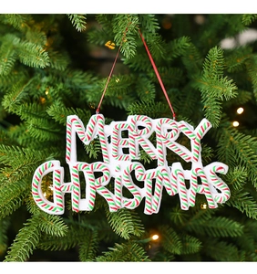 Macro shot of polymer clay Merry Christmas sign hanging on festive tree branches