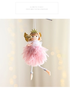 Detail of pink plush angel doll ornament with gold wings and heart on Christmas tree