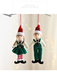 Detail of plush Christmas gnome ornaments hanging on a tree with festive bokeh lighting