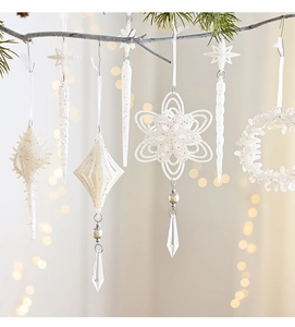 White Christmas ornaments with glitter, snowflakes, and drop crystals on a soft bokeh background