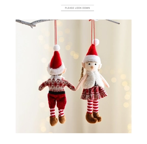 Detailed view of red and white plush Christmas elf ornaments hanging on branches