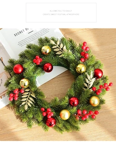 Close-up of artificial green Christmas wreath with red berries and golden ball ornaments