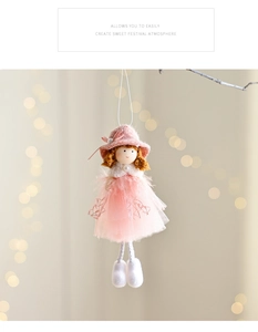 Detail of pink Christmas angel ornament with mesh skirt hanging on a branch