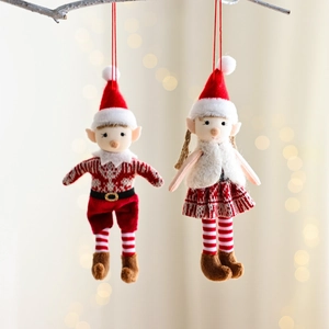 Pair of red and white knitted Christmas elf dolls hanging on a festive branch