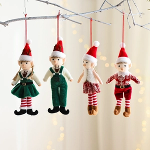 Four handmade Christmas gnome plush pendants hanging on a branch with warm festive lights