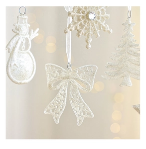 Close-up of glittery white Christmas ornaments with snowman and snowflake details