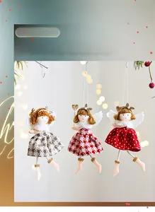 Three plush Christmas angel dolls with plaid skirts and wings hanging in festive decor