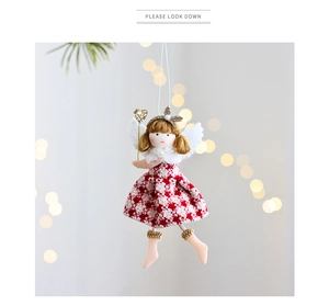 Detail of plush Christmas angel doll with red floral skirt and golden sequin heart wand