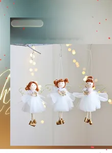 Detailed view of three white mesh angel ornaments with golden wings on Christmas tree