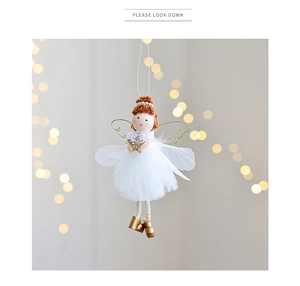 Detailed view of Christmas angel ornament with white mesh skirt and golden wings