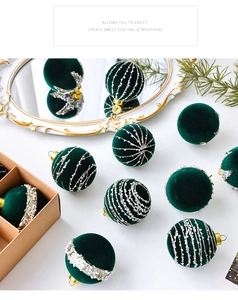 Detail of dark green velvet Christmas ball with silver glitter patterns and gold hook