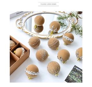 Detailed view of beige Christmas ornaments with silver stars and pearl beads on pine branches