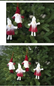 Gros plan de gnomes de Noël en feutre rouge et blanc suspendus aux branches du sapin
