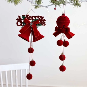 Détail de cloches de Noël floquées rouges avec signe Merry Christmas sur branche de sapin