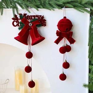 Détails de cloches de Noël en velours rouge avec pompons sur fond de branches de pin