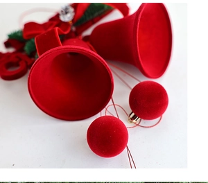 Détail de cloches de Noël rouges floquées avec aiguilles de pin et nœuds velours