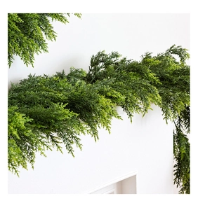 Dettaglio di ghirlanda di cedro in PE artificiale su un caminetto bianco per Natale