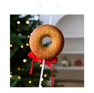 Détail d'une bougie en forme de donut avec texture cuite et nœud rouge festif