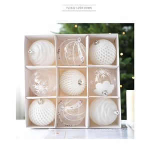 Set of nine white Christmas ornaments with snowflake patterns in a decorative gift box