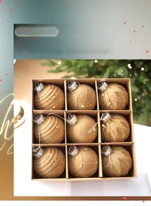 Detailed set of nine cream flocked Christmas balls with gold sequins in a kraft box
