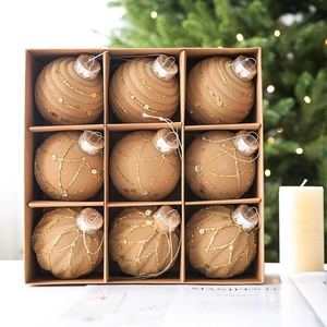 9-piece set of earth-tone flocked Christmas balls with gold glitter patterns in a gift box