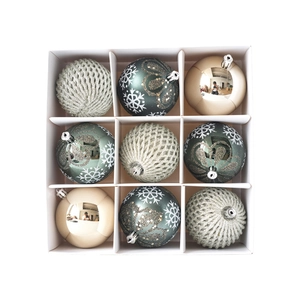 9-piece set of emerald green and silver painted Christmas tree baubles in a grid box