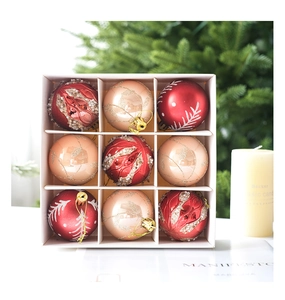 Detailed view of 9-piece red and champagne gold Christmas balls in a gift box