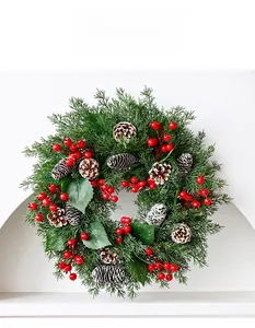 Detailed view of Christmas candle ring with pine needles, red berries and frosted pinecones