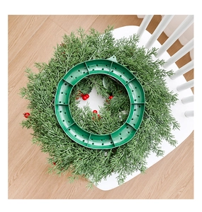 Detail view of Christmas wreath back with pine needles, red berries, and green plastic base
