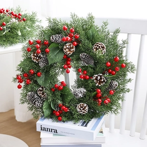 Christmas pine needle wreath with red berries and frosted pinecones for front door decor
