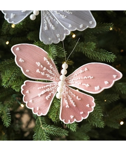 Detailed close-up of sequined fabric butterfly ornaments with pearls on a Christmas tree