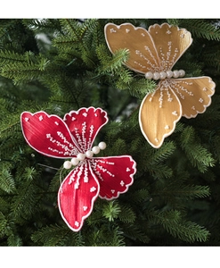Detailed view of festive red and gold fabric butterfly ornaments with pearls on a Christmas tree