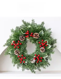 Détail de couronne de Noël avec baies rouges, aiguilles de pin et pommes de pin