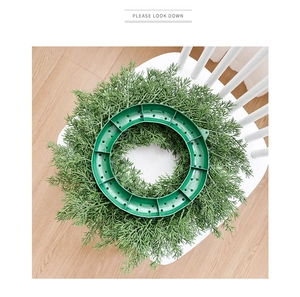 Vue verticale d'une base de couronne de sapin artificiel vert sur chaise blanche