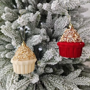Detailansicht von Cupcake-Weihnachtsanhängern mit Pailletten und Perlen am verschneiten Baum