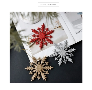 Close-up of glittery red, silver and gold snowflake ornaments with hanging strings