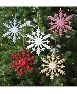 Detail of colorful glittery snowflake ornaments with hanging ropes on a Christmas tree