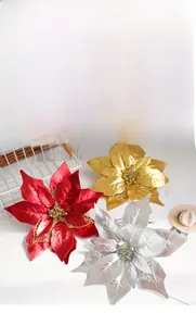 Detailed view of artificial Christmas poinsettias in red, gold and silver for tree decor