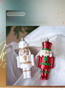 Detail von glitzernden Nussknacker-Anhängern in Perlweiß und Rot für den Weihnachtsbaum